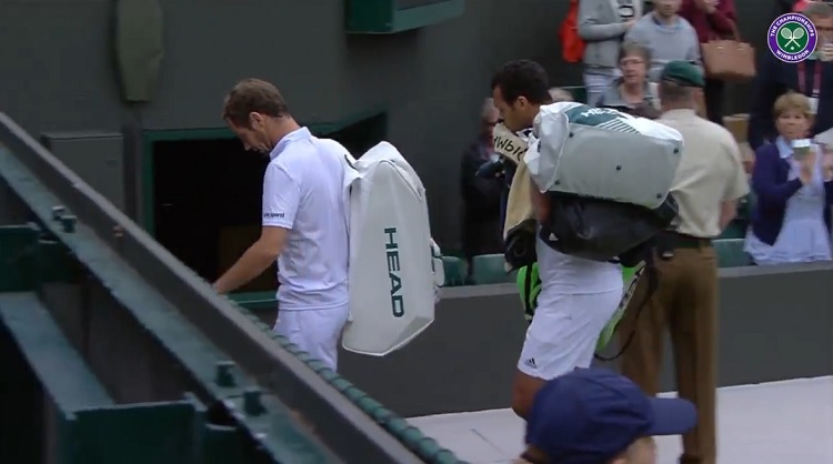 Jo-Wilfried Tsonga porte un des sacs de Richard Gasquet en sortant du court.