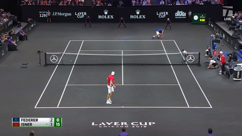 John Isner contraint Roger Federer à mettre une main à terre sur un service au corps surpuissant lors de la Laver Cup 2018. John Isner contraint Roger Federer à mettre une main à terre sur un service au corps surpuissant lors de la Laver Cup 2018.