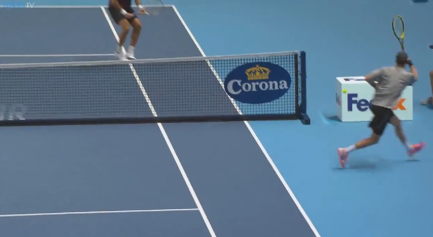 Le balle de Mike Bryan passe entre le filet et la publicité.